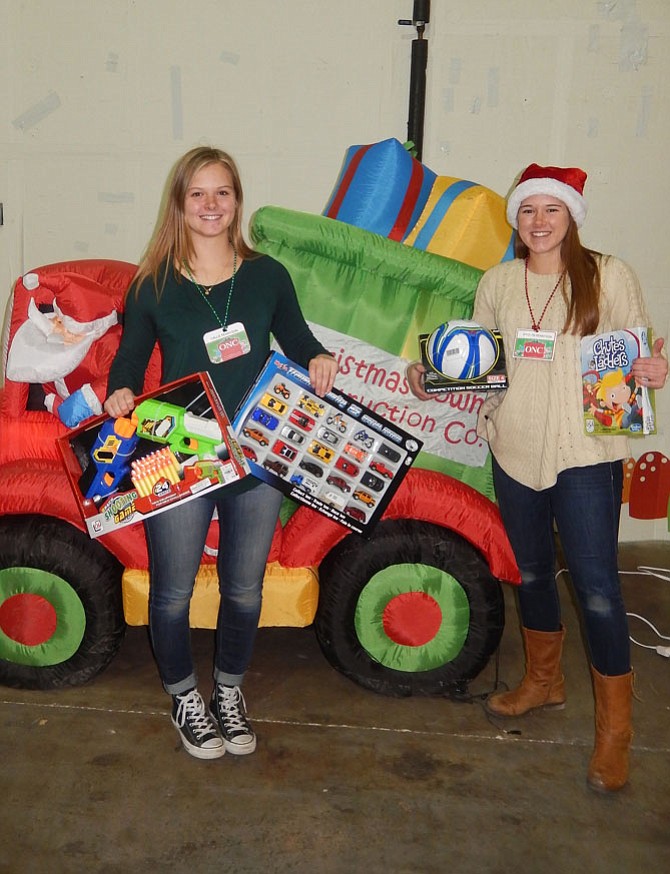 Sisters and Westfield High grads, Callie (left) and Katelyn Rennyson, hold some toys ready for packing.