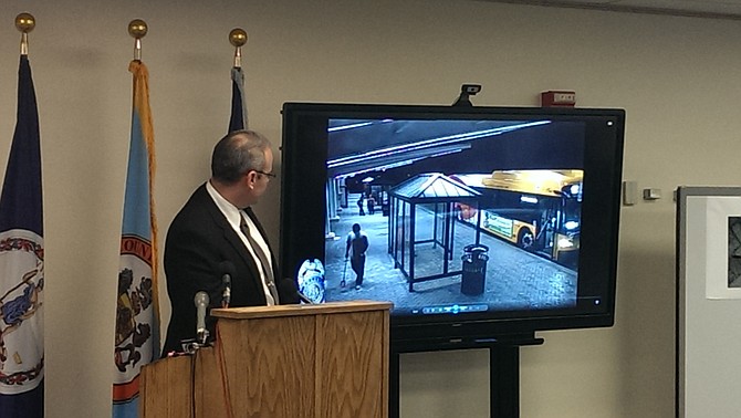 Left, David Smith, commander of Fairfax County Police Department major crimes division, breaks down the security camera footage of events leading up to and following Yovani Amaya Gomez (pictured on screen holding a sign post he used to attack a security guard and Sheriff’s deputy) being shot by Master Deputy Sheriff Patrick McPartlin.