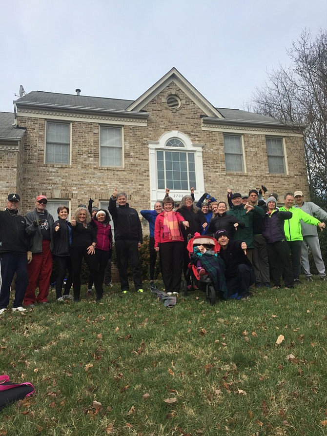 New Year’s Day runners from Great Falls Hash House Harriers give the thumbs up or thumb down sign to indicate if they’ve made a New Year’s resolution.  Gathered at the home of Mark and Cynthia Revesman near Frying Pan Park, the hashers are set to begin their Annual New Year’s Day Run.