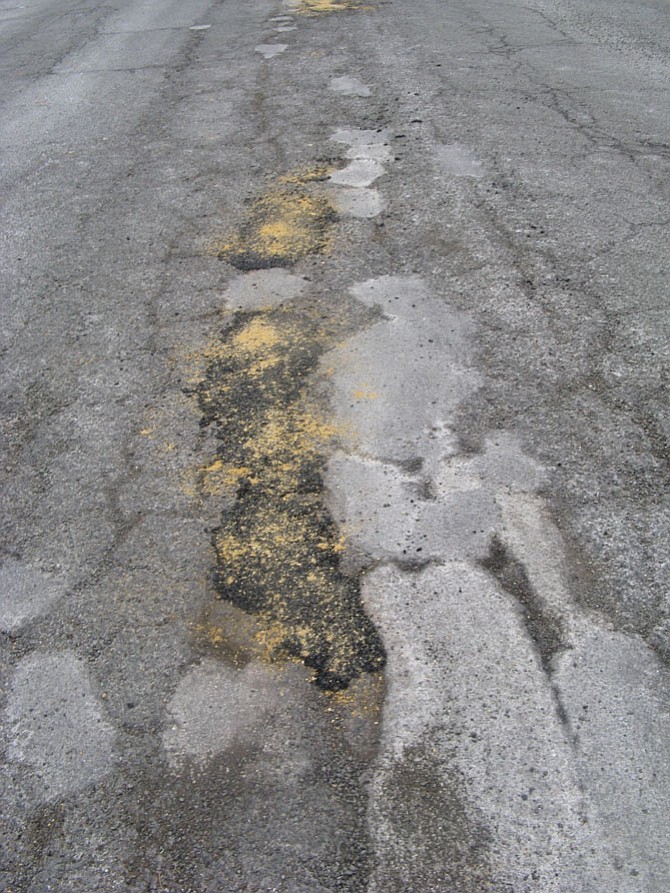 Photo showing the previous patches on South Pitt Street as well as the sand-and-asphalt patches just installed.

