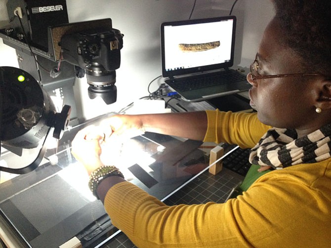 Kimberly Wade, laboratory technician, positions a prehistoric potsherd for a photograph.