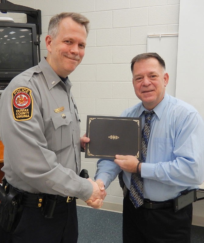 1st Lt. Alan Hanson (left), assistant commander of the Sully District Station, presents the Officer of the Month certificate to Det. Steven Kitzerow.