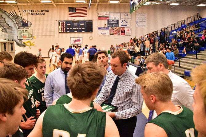 Head Coach for Langley, Scott Newman and assistant coaches Andrew Hypnar and Billy Wilkerson discussing plays with their team at the end of the first quarter.