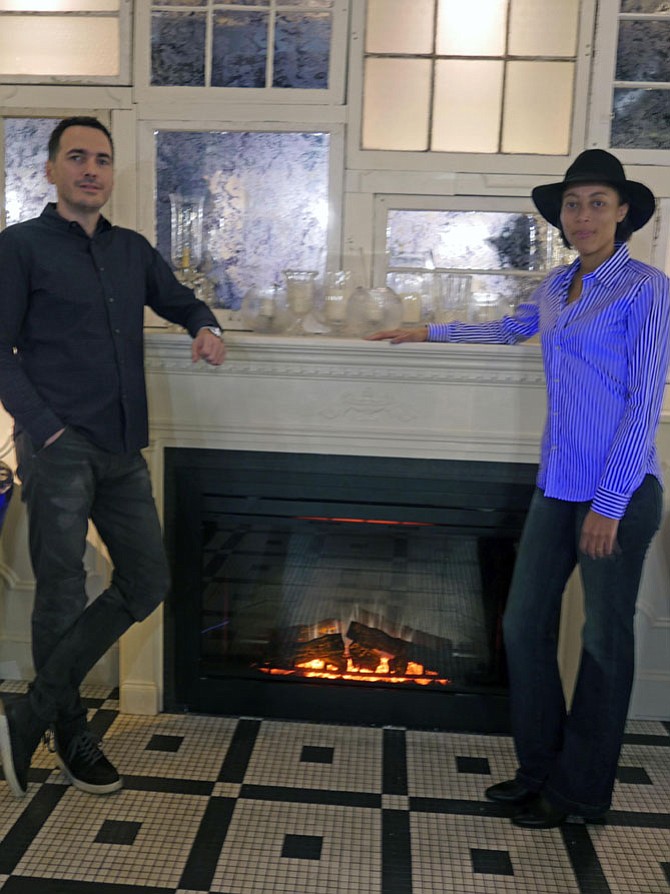 Ivan Iricanin and his wife Nya Gill stand before the fireplace meant to create a warm and cozy space in BABA, a new neighborhood gathering spot. He explains that BABA means grandmother in Serbian, and it is cozy and warm, just like memories of your grandmother. 