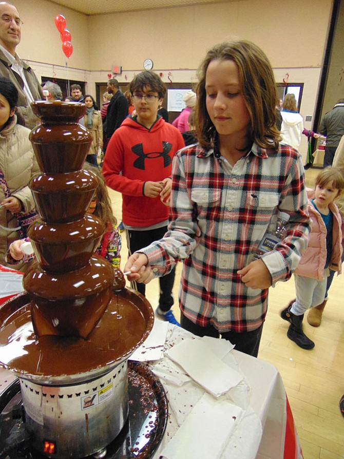 Toby Thierer, 12, of McLean, tries his hand at the Chocolate Fountain sponsored by Chesterbrook Residences Assisted Living of Falls Church during the Sixth Annual Chocolate Festival on Sunday, Jan. 29, 2017. The event was sponsored by the Rotary Club of McLean at the McLean Community Center.
