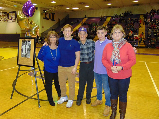 (From left): Family members Juliane Carson Wines, Tyler Wines, Robert Carson, Joshua Wines, and Susan Jones at half-time during the Lake Braddock basketball game of the gym rededication ceremony for Robert Carson.
