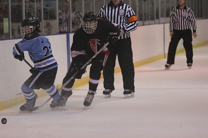 Warhawks defenseman Nick Willey battles at the boards to keep the puck in Yorktown’s defensive zone. The Warhawks clinched a playoff spot with their 3-1 win over Yorktown. 