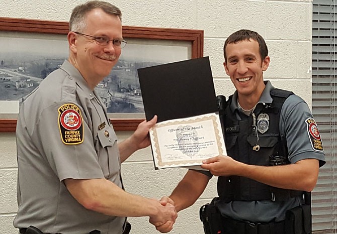 Assistant Station Commander Alan Hanson (left) gives PFC Ramsy Saffoori his Officer of the Month certificate.