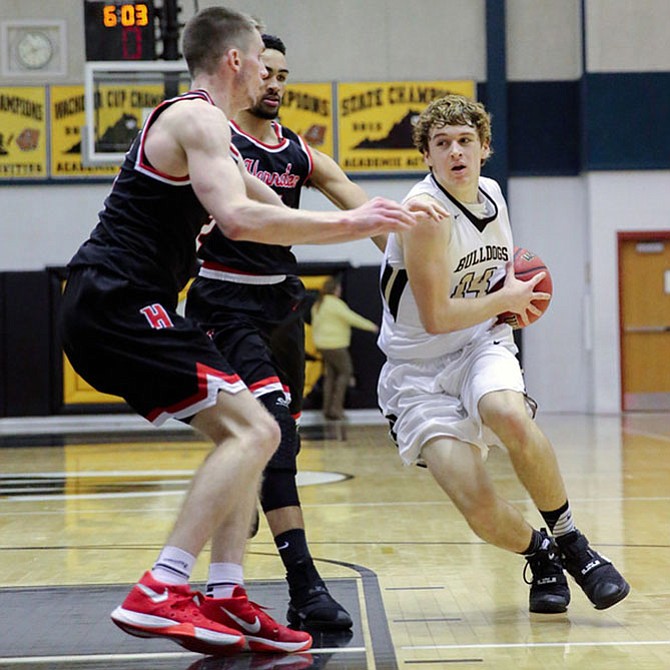 Gavin Kiley#14 drives against two Herndon defeders