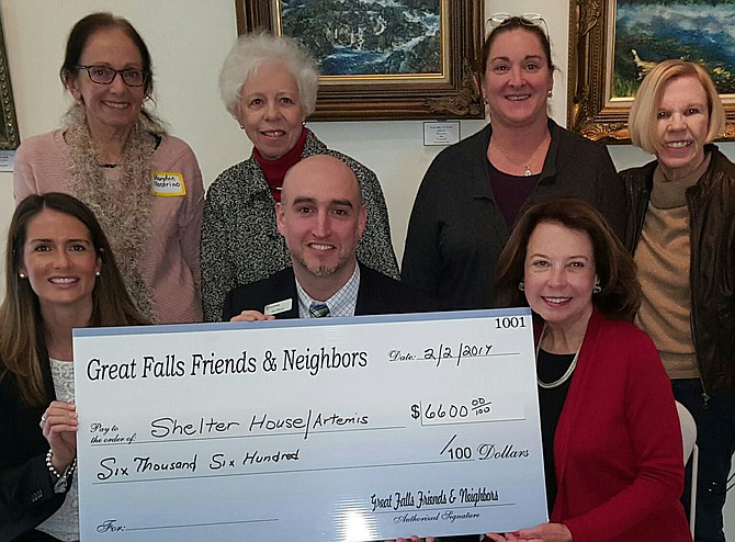 Artemis House Executive Director Joe Meyer and Director of Development Jennifer Delessio [front row left] accept the donation from the Great Falls Friends and Neighbors, surrounded by members of the organization. The funds were raised through the club's annual White House Ornament holiday fundraiser.
