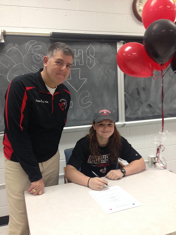 Bea Kelly-Russo and Cpt. Adler signing the intent form for Lynchburg College Women's Soccer.