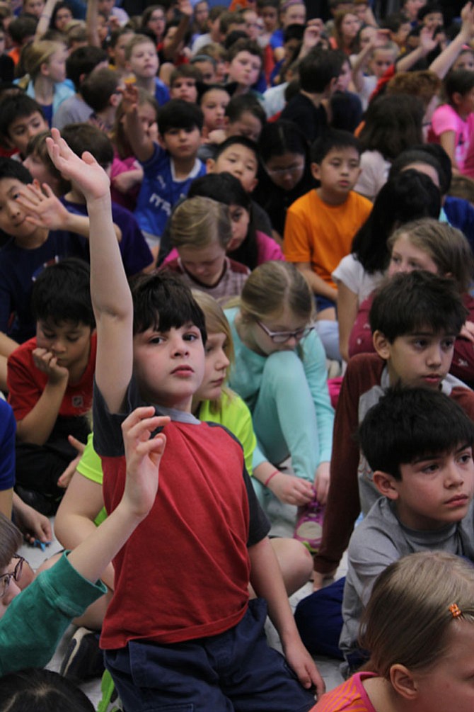 Student Omar Hallab raises his hand to ask Astronaut Sandy Magnus a question during the assembly.