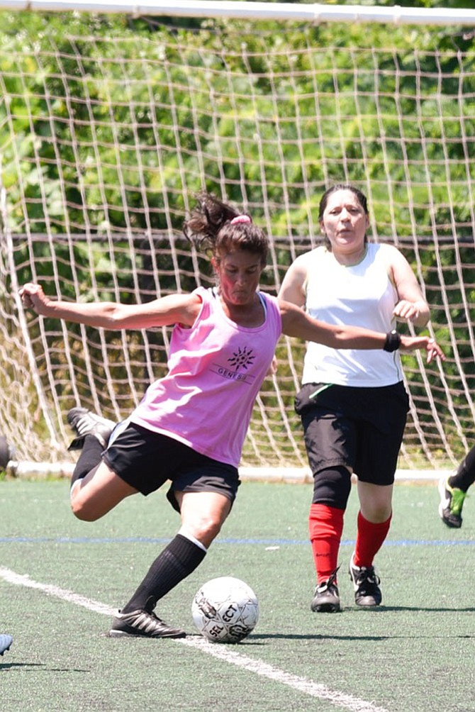 Team Genesis player, Terry Buchholz hoping to score a goal during a Fairfax Women’s Soccer Association game, with Carmen Toscano of Hot Tamales in pursuit. Players from 18 to 78 have been playing in the league for more than 40 years. 