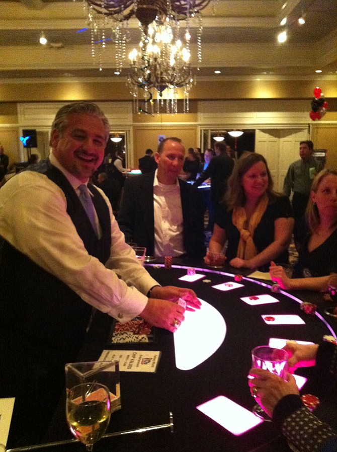 Vienna Rotary president A.J. Oskuie has fun while dealing cards at a gaming table at Casino Night.