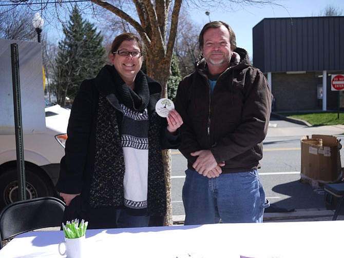 Dr. Karyn Ewart and Science teacher Bryan Shaw stand at the Sycamore School table at Westover Farmers Market on a Sunday morning. The name ”Sycamore,” says Ewart, symbolizes the school in the sense that it is an organic form which gives kids roots to grow strong. 
