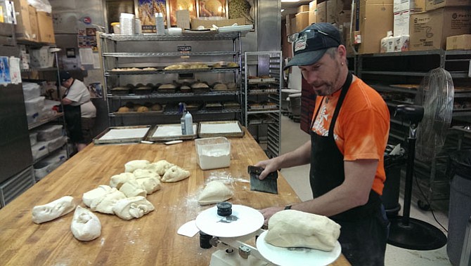 At 4 a.m., while most people sleep soundly, Jeffrey Connelly is up baking bread in Burke. Here he’s cutting white bread before the sun is up.
