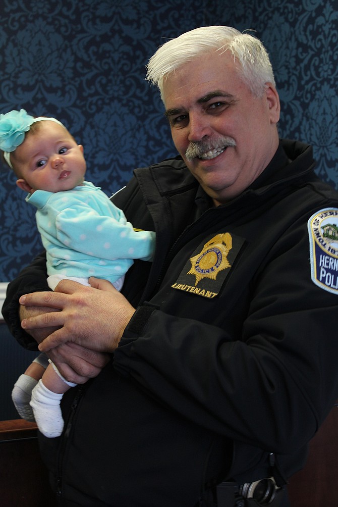 Herndon Police Department Lt. Michael Berg scoops up 4-month-old Lila Cannell while he speaks with her mom, Shannon Cannell, during the “Coffee with a Cop” event at the Virginia Kitchen restaurant on Monday, March 13.
