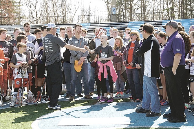 SYA lacrosse player Tatum Bulger receives a custom-made lacrosse stick.