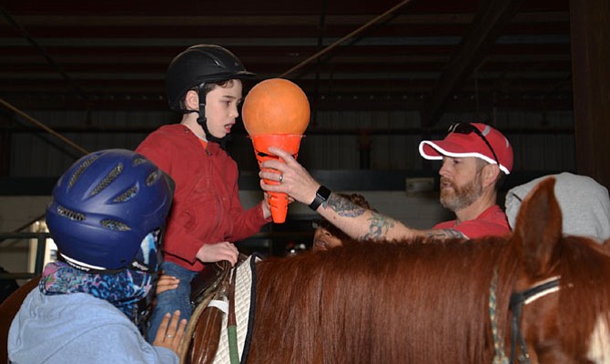 Aaron Roethlisberger, 9, is given a coordination task by director/assistant instructor Aaron Fleet, who came to Spirit two years ago with no experience with horses or special needs individuals. “I was just looking for some volunteer work, like maybe mucking stables, helping around the farm.” Davorka “Dada” Suvak saw his potential and now the Restonian is “learning and growing with all of the Spirit gang.”