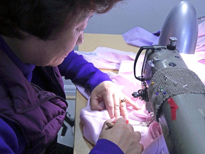 Sun Lee, tailor at Suh’s Custom Tailors, double stitches the seam on a man’s shirt. This will take her about 45 minutes.