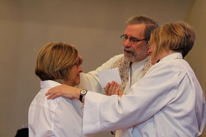 Pastor Hank Langknecht and assisting minister perform the rite of laying on of hands and anointing for healing on a congregant during the service on Sunday, April 2.