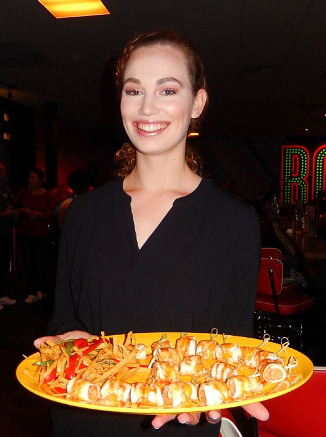 Leslie Noble holds a platter of mango chicken chipotle wraps.