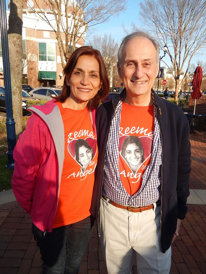 Mona and Joe Samaha wearing T-shirts imprinted with their daughter Reema’s face.
