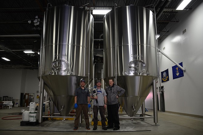 From left, Fair Winds Brewing Company’s Max Courington, Charlie Buettner and Will Sonneman in front of new 120-barrel fermentation tanks.