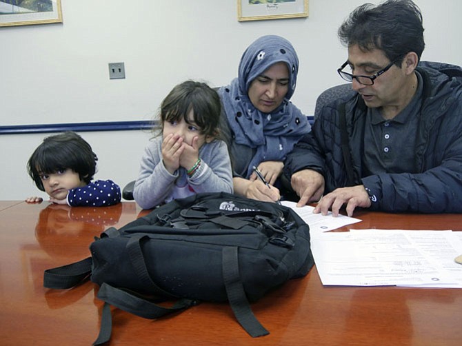 Mohammad Yaqoobi and his wife Homa sit with Natasha Jones at the Alexandria Workforce Development Center on Beauregard Street getting an orientation to the Virginia Initiative for Employment Not Welfare (VIEW) program. The family arrived from Afghanistan five months ago where Yaqoobi was a teacher and served with U.S. military forces. 