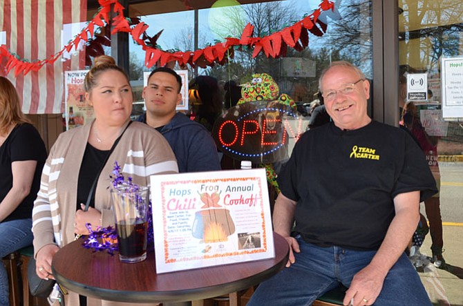 From left, Tiffany and Silfredo Sosa (aunt and uncle of Carter Dean) of Lorton, and Dennis Dean (Carter’s grandfather) attend the Hopsfrog Grille chili cook-off April 8.