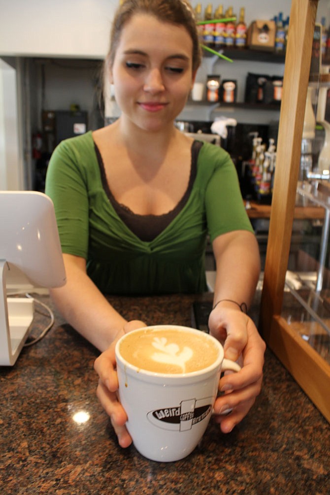 Maddy Toland, assistant manager, serves up a latte on Wednesday, April 19. She is the Weird Brothers Coffee “master of latte art.”