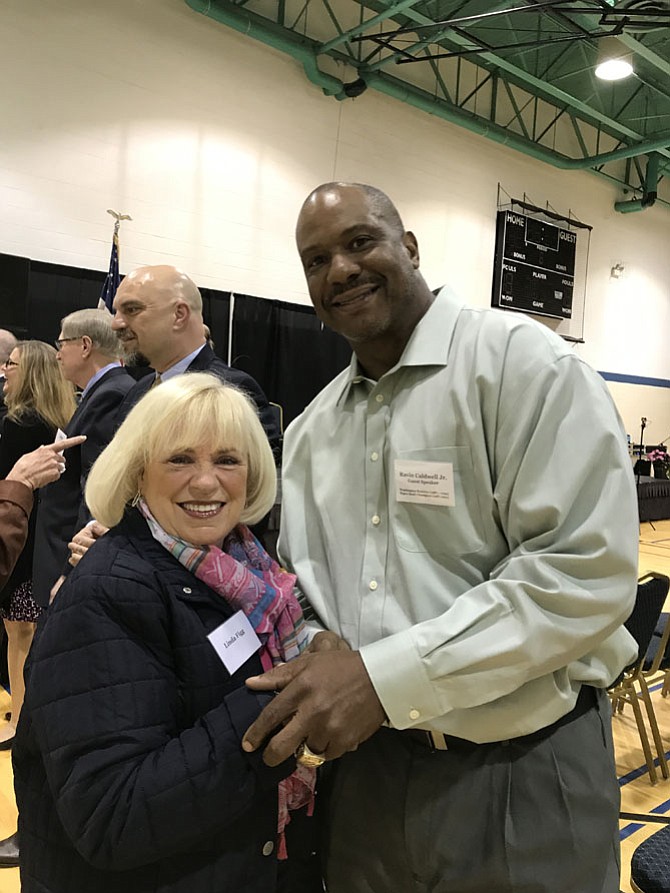 Ravin Caldwell Jr., former Washington Redskin linebacker, two-time Super Bowl champion and resident of Herndon welcomes Linda Figg, one of the 430 Outstanding Service Award Recipients, at the 33rd Annual Mayor's Volunteer Appreciation Night held Sunday, April 23.