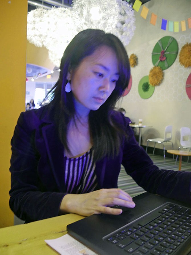 Wendy Chan, a co-founder of NOVA Friends of Refugees, pulls out her computer to illustrate the three 2017 goals of the volunteer organization: advocacy, life skills program and community events.