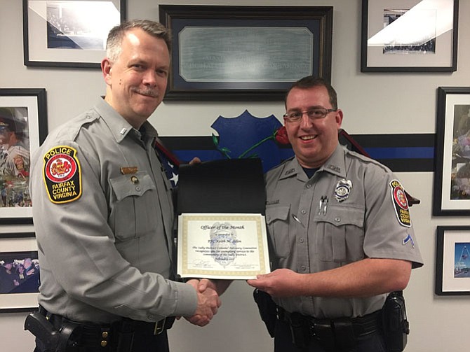 Lt. Alan Hanson (left), assistant commander of the Sully District Station, presents the Officer of the Month award to PFC Keith Allen.