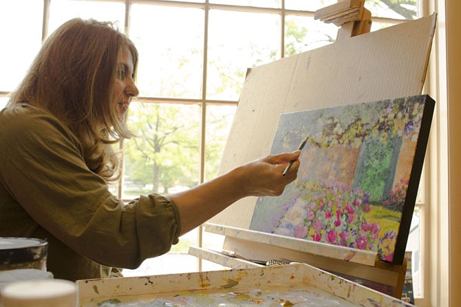 Layla Gray works on an oil painting of a Monet garden she saw during a trip to France at the Artists on the Green studio.
