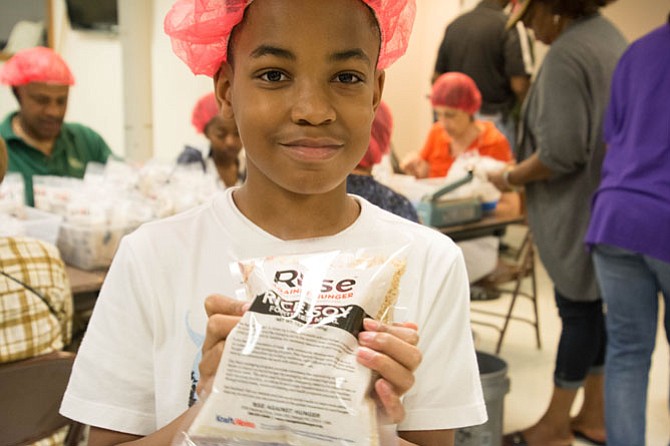 Benita Park’s son, Kendall holds a finished package of Rise Against Hunger packaged meals. The volunteers met their goal of packaging 50,000 meals this year, 20,000 more meals than last year.