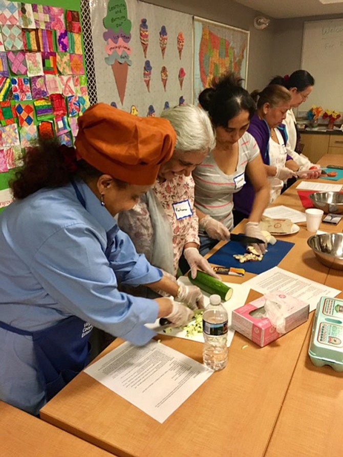 Participants gathered around a table at Buchanan Garden Apartments May 3 to make a vegetable frittata as part of the “Let’s Get Cookin’” program.