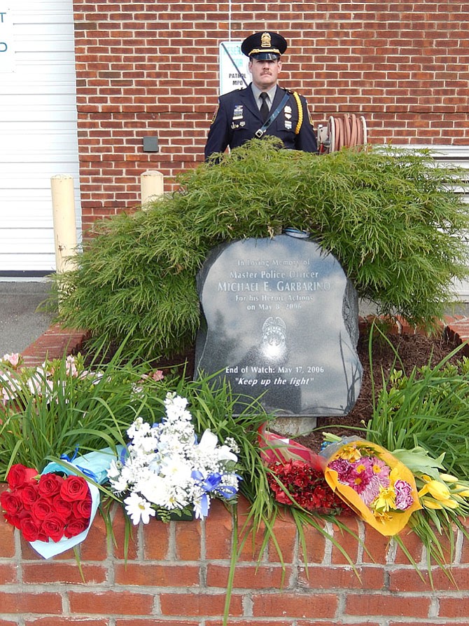 2nd Lt. Chris Cotone stands at attention behind MPO Mike Garbarino’s memorial at the Sully District Police Station.
