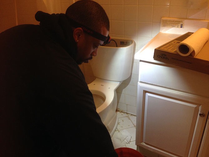 Nate Bennett from Chandlers in Falls Church works on the bathroom.