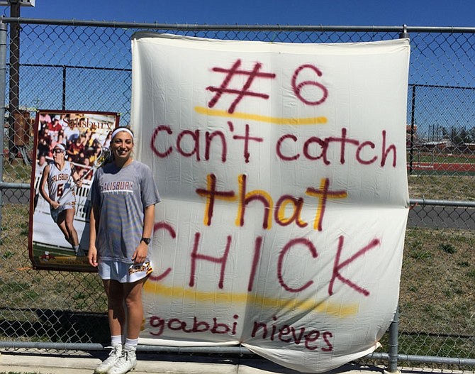 Gabbi Nieves in front of the banner her college teammates made for her in April.
