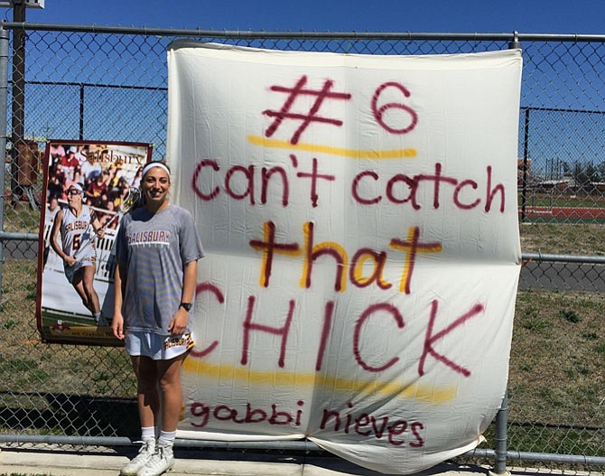 Gabbi Nieves in front of the banner her college teammates made for her in April.
