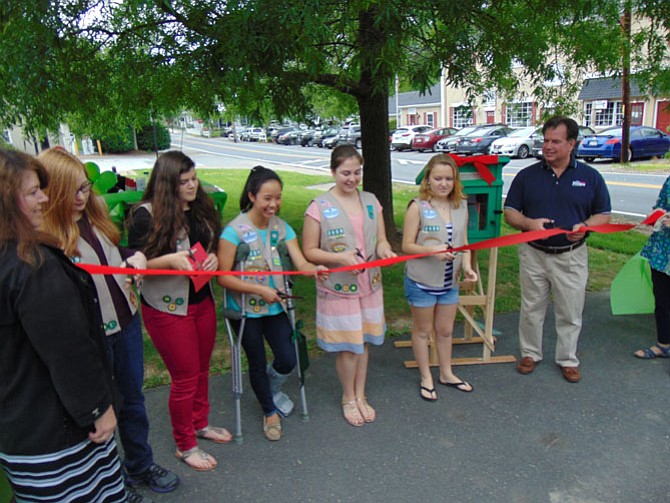 Girl Scouts from Troop 2009 of St. Andrew's Catholic Church and Del. Tim Hugo cut the ribbon during the ribbon-cutting ceremony of the Little Free Library in Clifton.