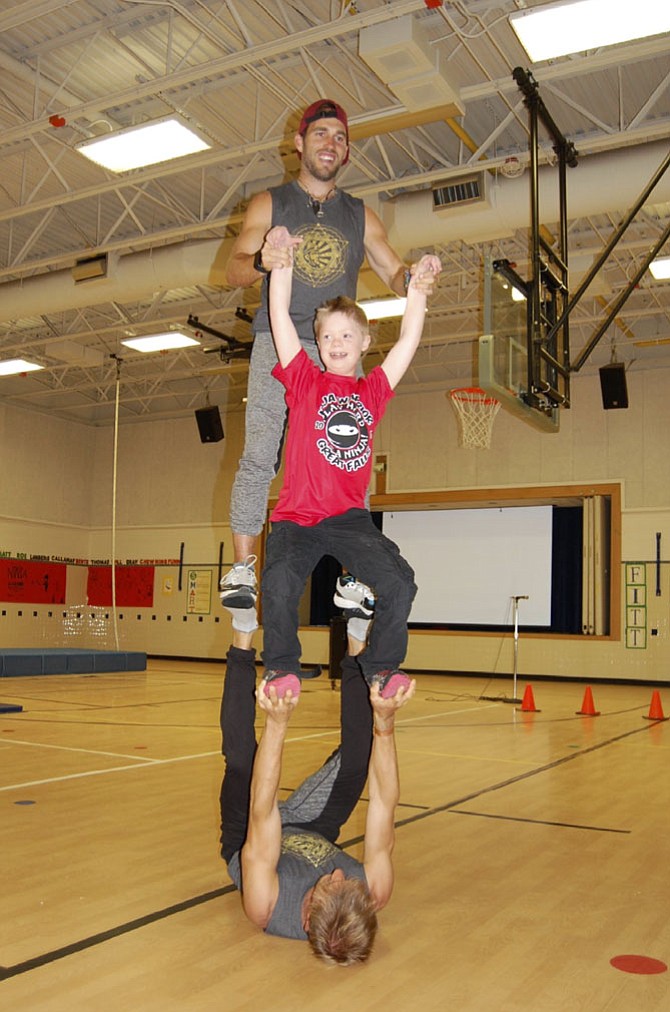 Great Falls Elementary fourth Grader Simon Killian gets a lift during the “American Ninja Warrior” demonstration at the school.
