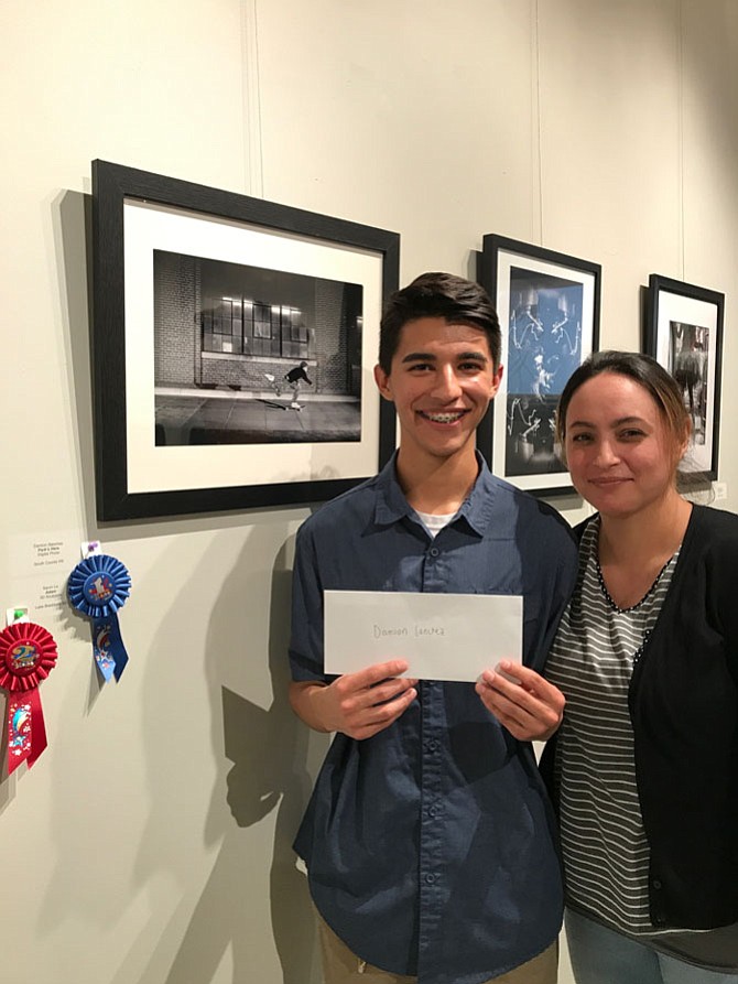 Damion Sanchez from South County High School in Lorton, pictured with his mother,  Cynthia Sanchez, won 2nd Place and a cash award of $750 for his digital photo, “Park’s Here” in Arts Herndon’s Technology + Art = Now Competition open to students in all Fairfax County Public Schools. Damien said, “I wanted to shoot this exact photo… it took me four takes to get the light and pose right.” Damien will attend California State Long Beach majoring in Business Management. “Hopefully I’ll become a freelance photographer after a successful business career. My money from business; my passion from photography.”
