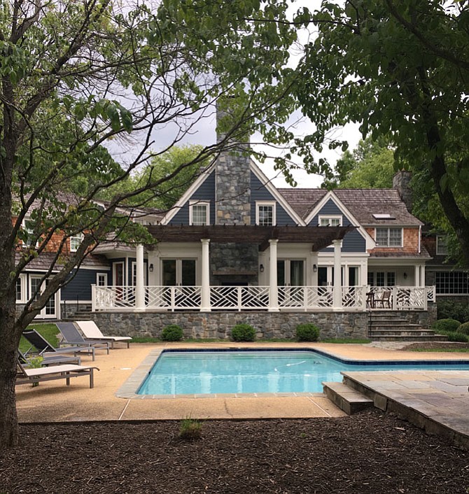 This patio in Potomac, Md., was designed by Rill Architects and includes a stone wall above the pool.  