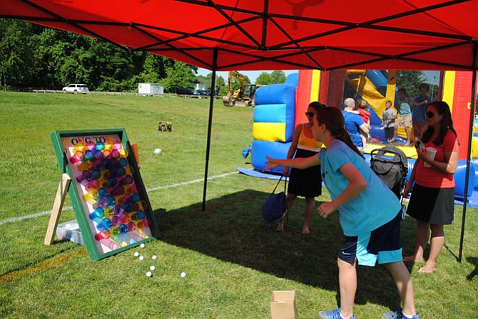 Ella Miner, GFSC member, enjoying a game of pong toss while Mother, Silva Miner, and Auseh Britt, travel soccer team mother, watch. 