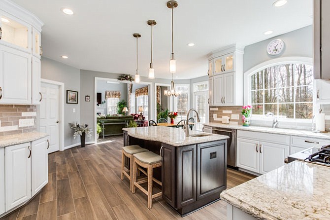 Dory Clemens at Foster Remodeling Solutions executed a kitchen upgrade in an 18-year-old Springfield home while staying within the footprint of the existing production house plan. To create light and visual continuum, a small casement window was replaced with a divided-light picture window. The food prep island and two-seat dining counter is positioned to support work triangles in three directions.
