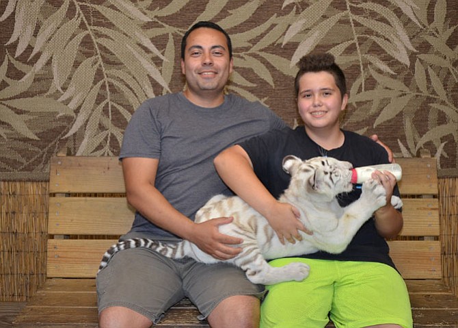 Gunner Dutzman and his father Patrick Medina bottle feed a baby tiger during a trip to Myrtle Beach, S.C.  