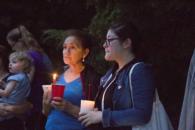In an act of solidarity, Isabel Membreno of Sterling, left, and Laura Fuents of Sterling join a group of nearly 40 community members who showed up on Monday, June 19, to stand watch as Muslims enter the ADAMS Center mosque in Sterling for their evening Ramadan prayers.