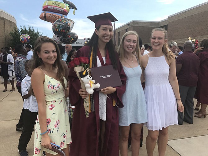 Surrounded by friends and gifts, graduate, Camile Guzman smiles for the camera.